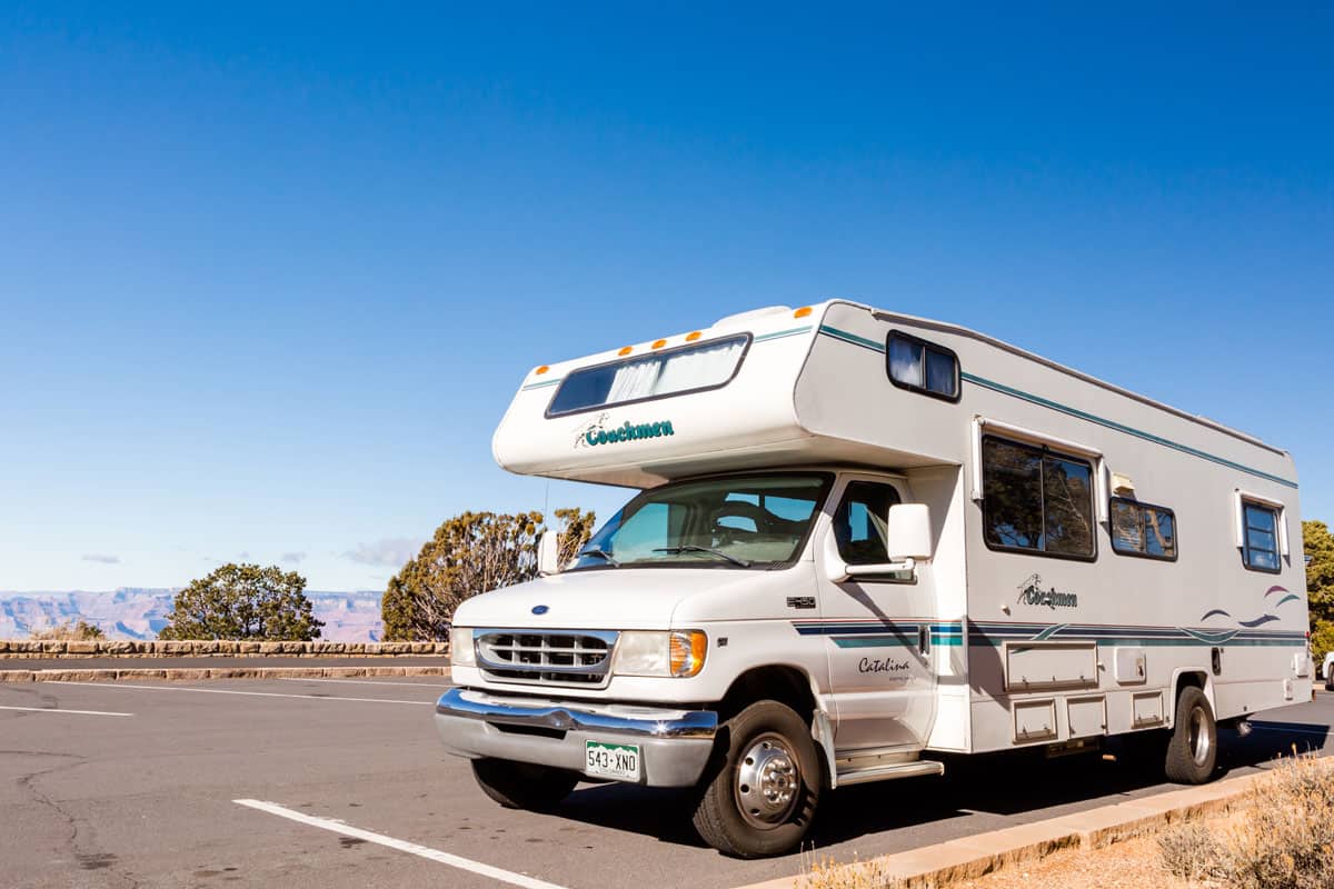 A white class C motorhome photographed in the camping grounds