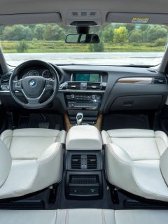 BMW X4 luxury crossover SUV with white, cream upholstery leather interior, bright and clean, with red stitching accents, detail photo, close up, inside the car. - Does BMW M8 Have Massage Seats?