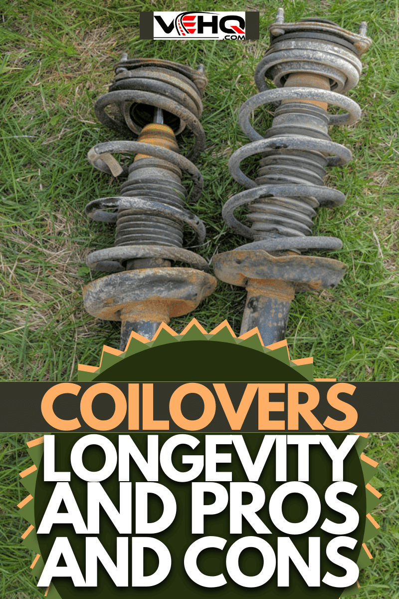 A pair of old rusty coilover struts laying on green grass before disposal.
, A pair of old rusty coilover struts laying on green grass before disposal.
