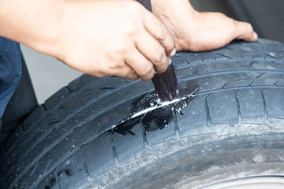 Series of mechanic patching puncture tubeless tire. Soapy water applied onto punctured area to check leakage.