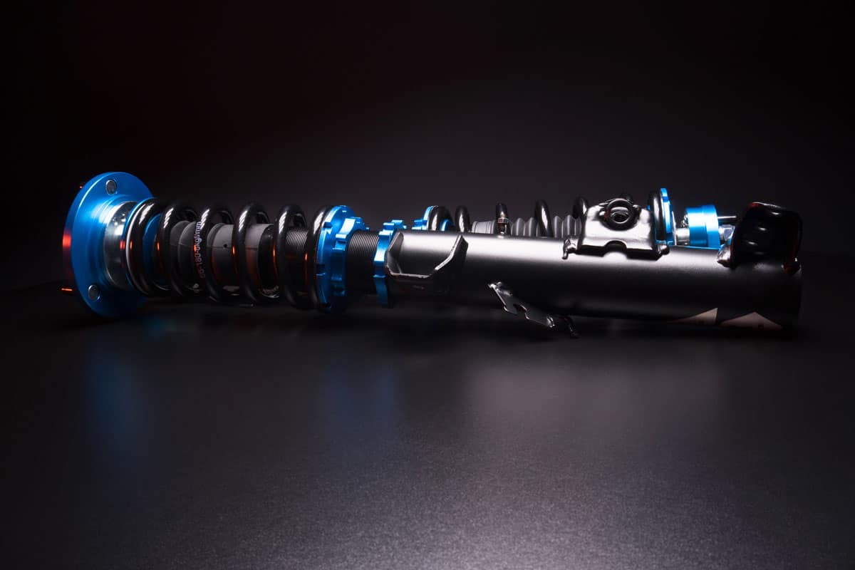 auto suspension tuning coilovers shock absorbers and springs blue for a sports drift car on a dark background
