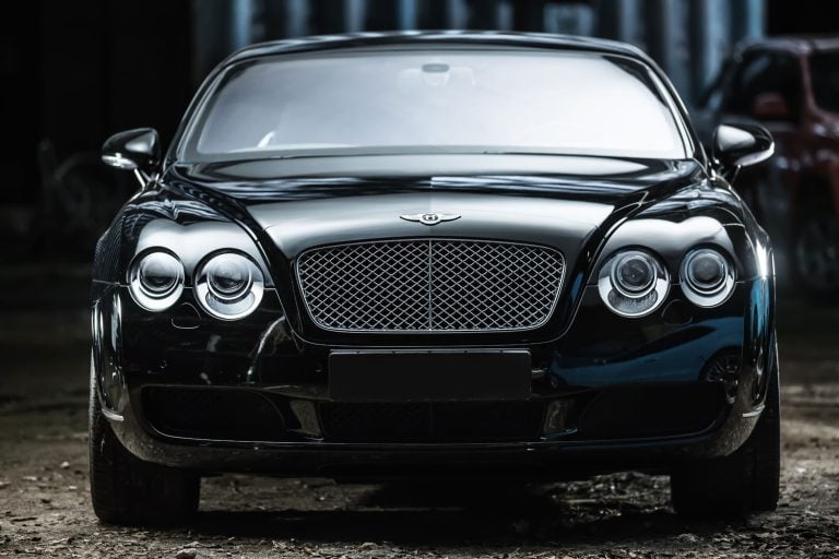 An editorial photo showcasing a black-colored Bentley Continental GT Coupe, a sport-car that has been tuned. The photo captures the front view of the vehicle. - How to Remove a Bentley Front Bumper
