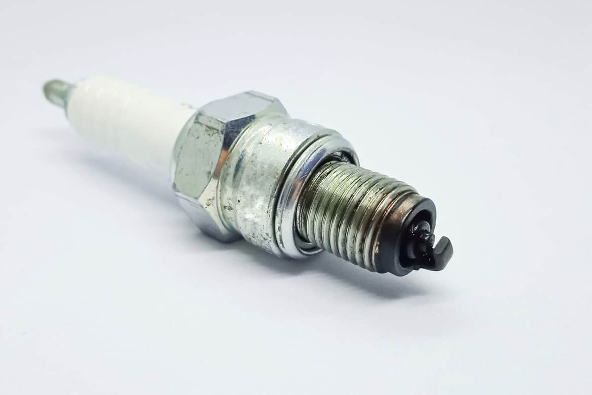 Used motorcycle spark plug, isolated on the gray white background
