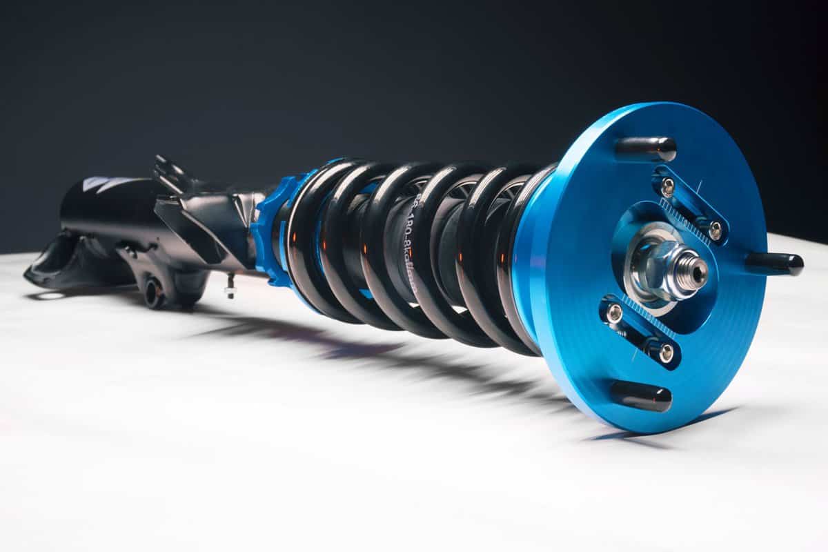 auto suspension tuning coilovers shock absorbers and springs blue for a sports drift car on a white background
