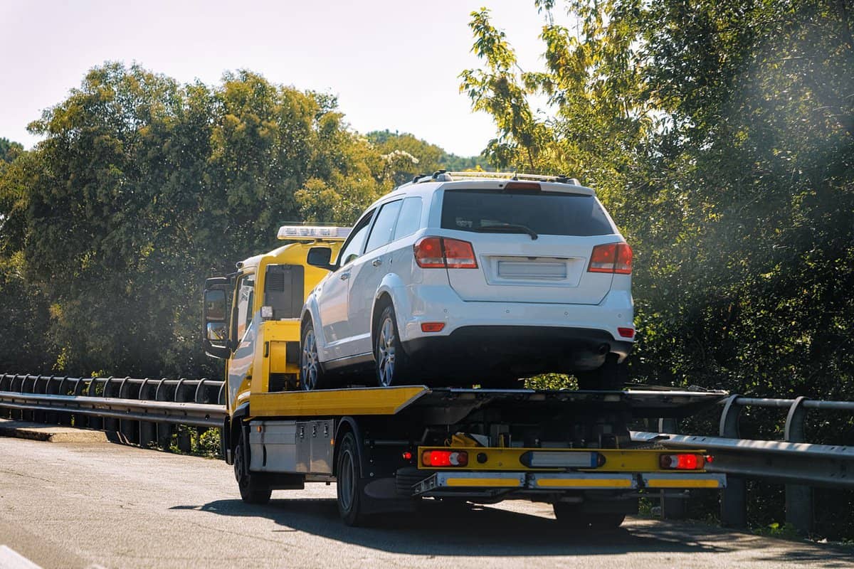 A truck towing a small SUV to the impounding area, Does OnStar Cover Towing? Friendly Guide to Services
