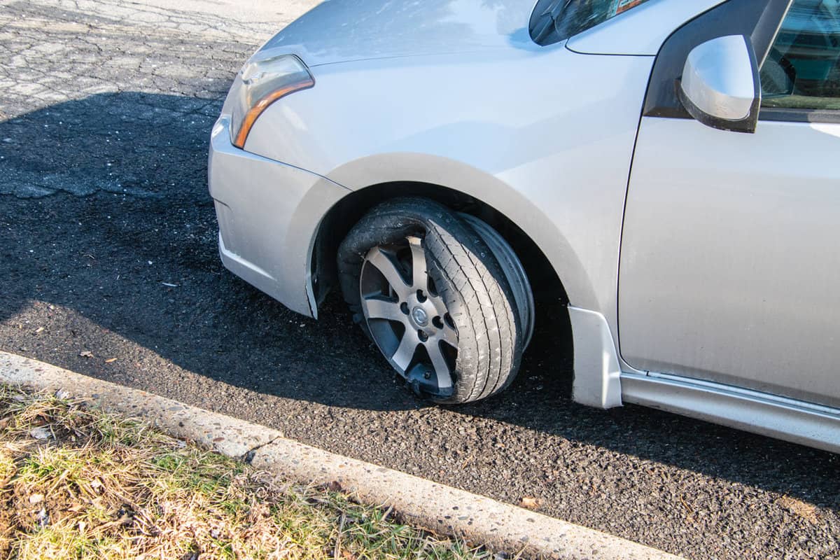 A car parked on the side of the car due to blown tire
