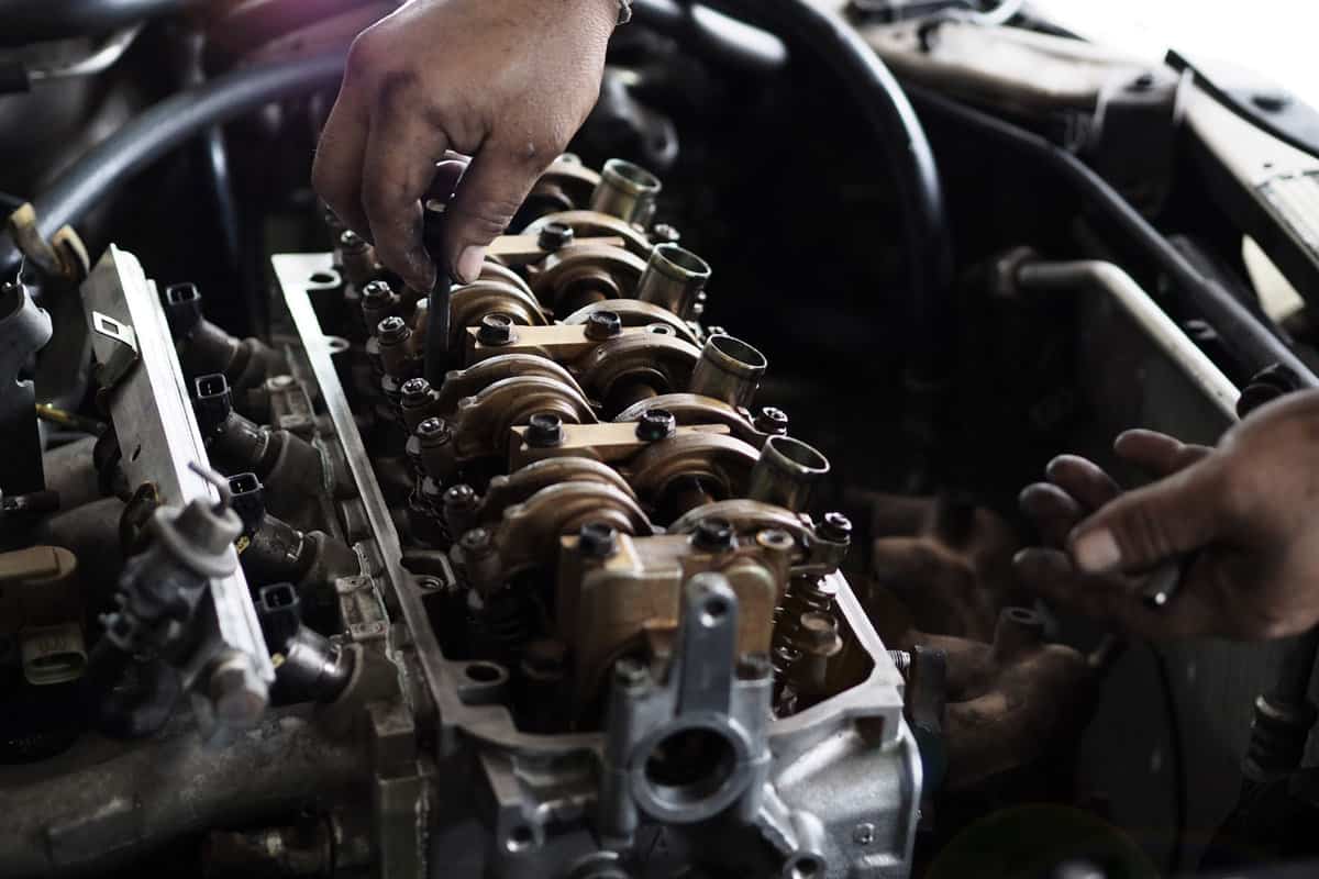 Mechanic checking the camshaft of a small car