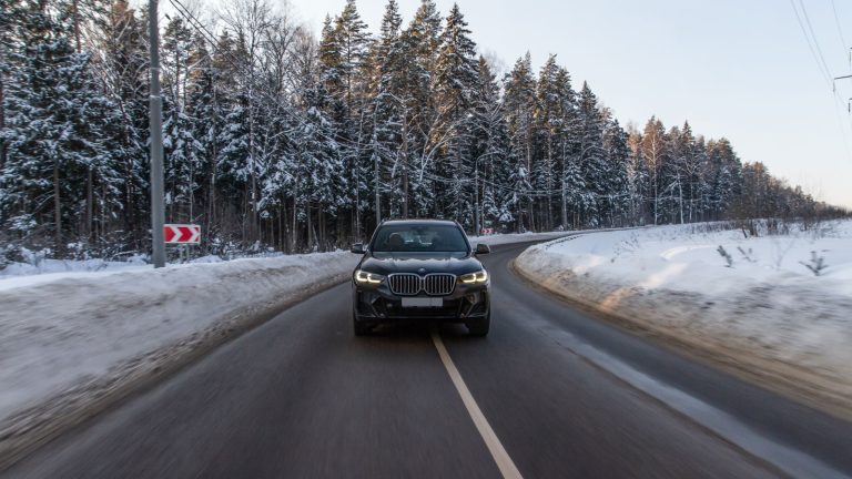 A BMW X3 moving on the half snowy roads, My BMW is Rattling When I Accelerate: Here's How to Fix It! - 1600x900