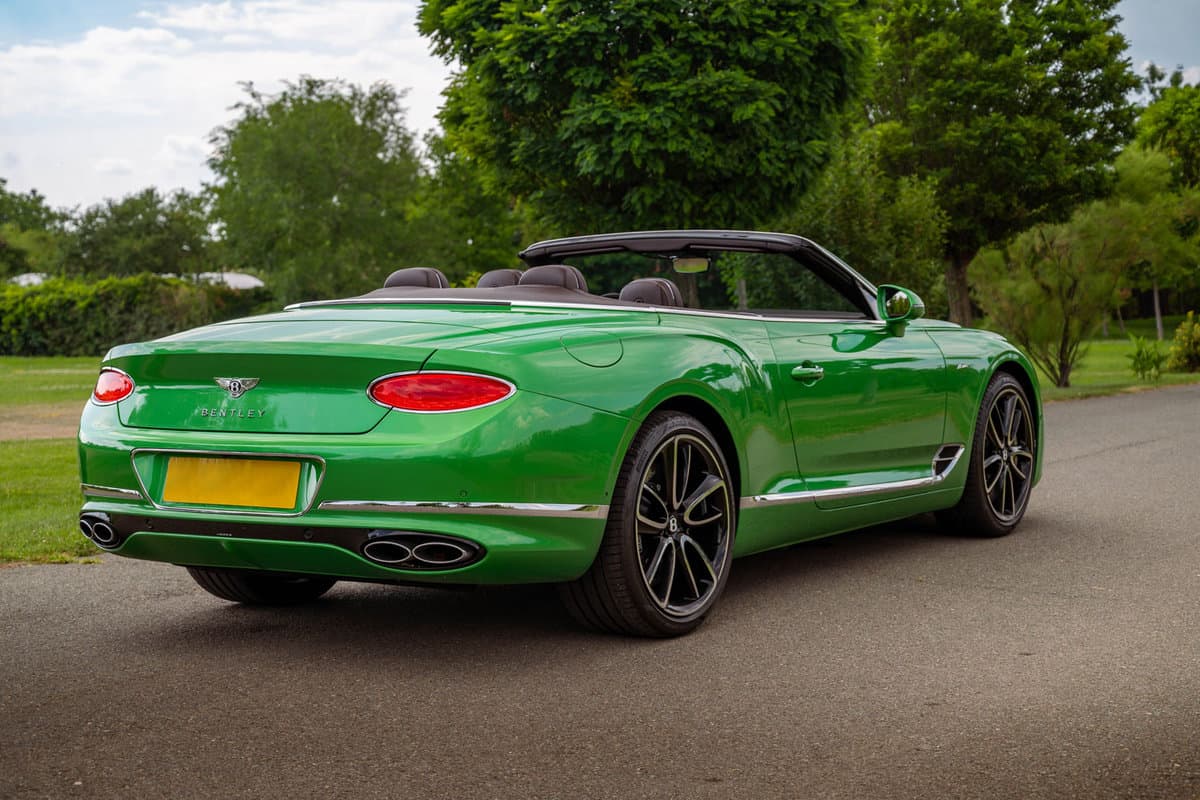A green Bentley parked on the side of the road
