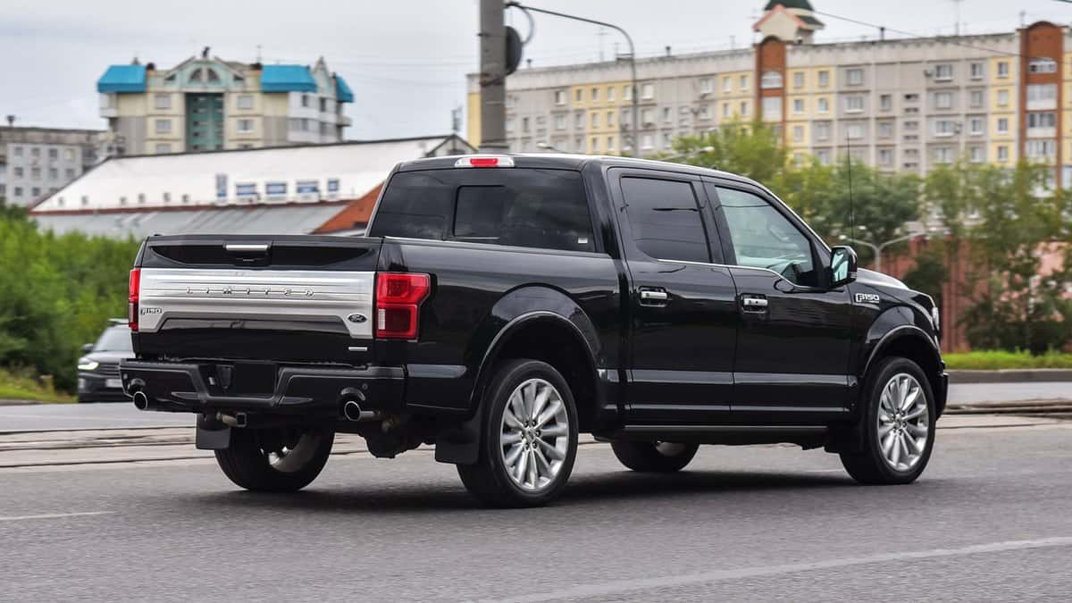 Ford F-150 Limited is driving on the road.