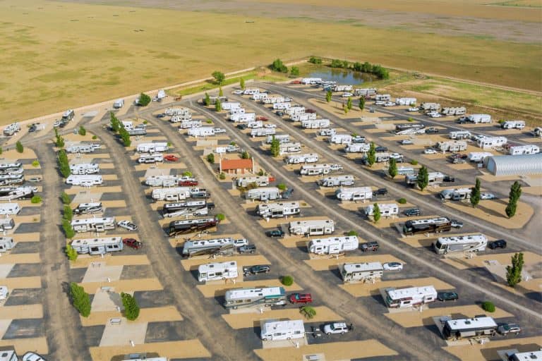 Rvs lined up in a large RV site property
