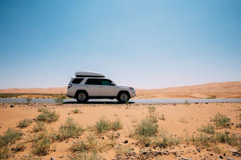 Driving White 2020 Toyota 4Runner TRD crossing in the desert road trip